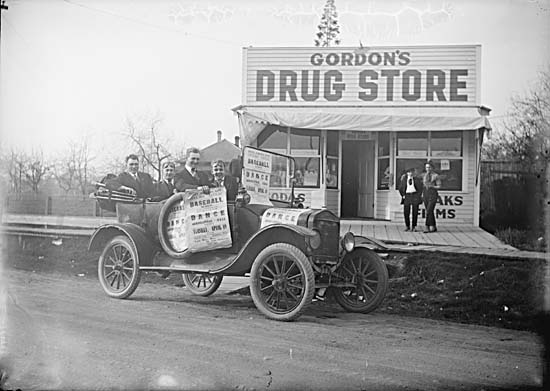People in automobile in front of Gordon's Drug Store