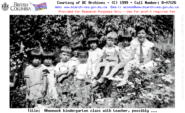 Whonnock kindergarten class with teacher, possibly T. Hedaka, posed in a garden.
